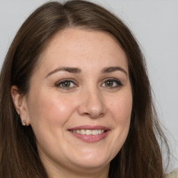 Joyful white adult female with long  brown hair and grey eyes