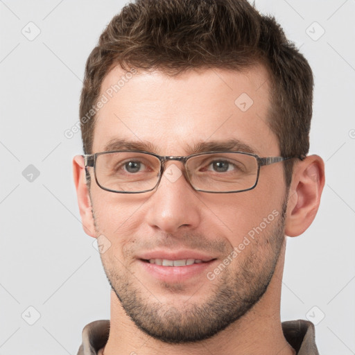 Joyful white young-adult male with short  brown hair and grey eyes