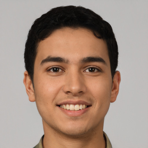 Joyful latino young-adult male with short  black hair and brown eyes