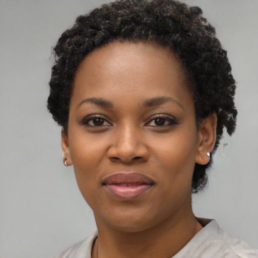 Joyful black young-adult female with short  brown hair and brown eyes