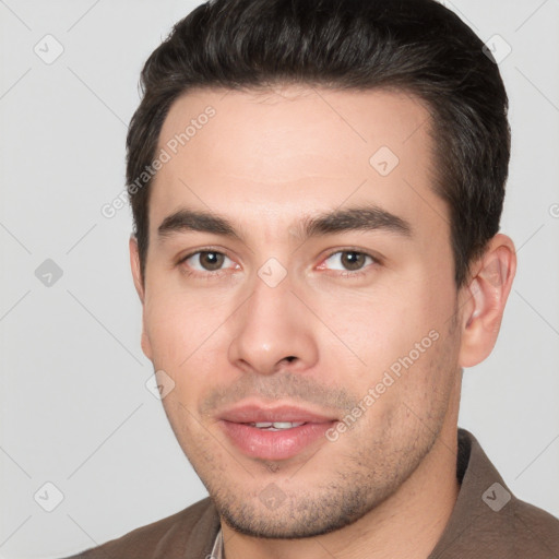 Joyful white young-adult male with short  black hair and brown eyes