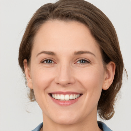 Joyful white adult female with medium  brown hair and grey eyes