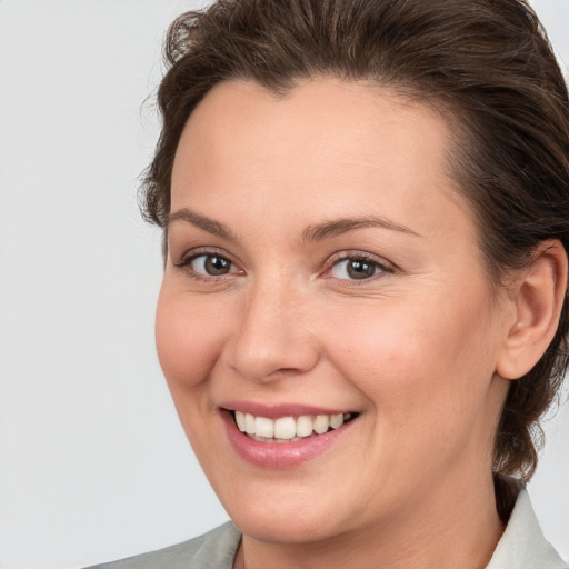 Joyful white young-adult female with medium  brown hair and grey eyes