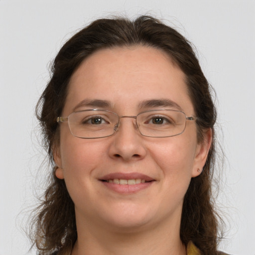 Joyful white adult female with long  brown hair and grey eyes