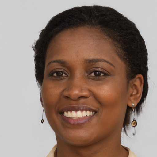 Joyful black young-adult female with short  brown hair and brown eyes