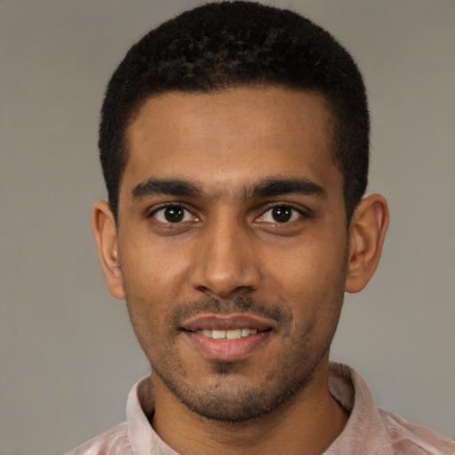 Joyful black young-adult male with short  black hair and brown eyes