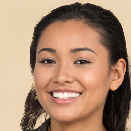 Joyful latino young-adult female with long  black hair and brown eyes