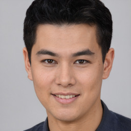 Joyful asian young-adult male with short  brown hair and brown eyes