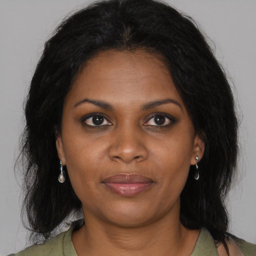 Joyful black young-adult female with long  black hair and brown eyes