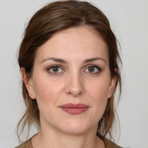 Joyful white young-adult female with medium  brown hair and green eyes