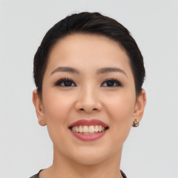 Joyful asian young-adult female with short  black hair and brown eyes