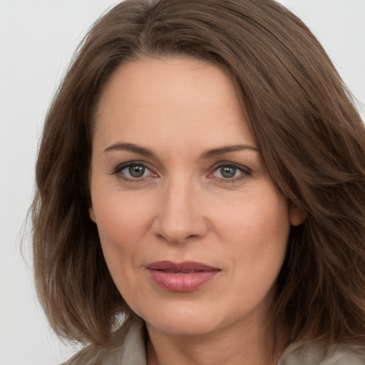 Joyful white adult female with long  brown hair and brown eyes