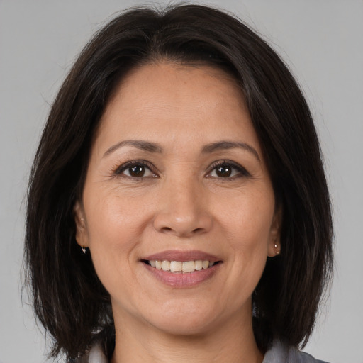 Joyful white adult female with medium  brown hair and brown eyes