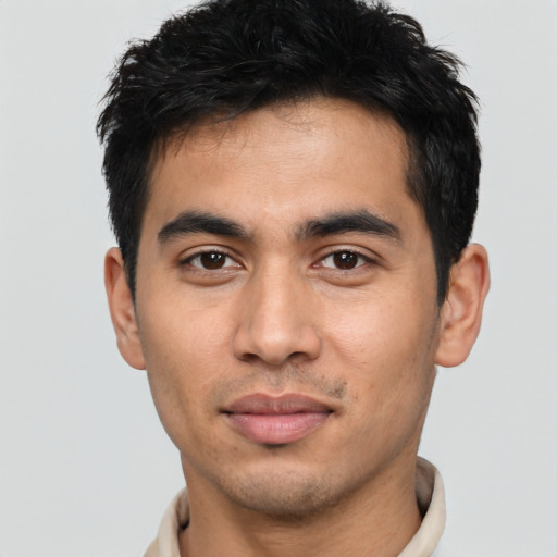Joyful latino young-adult male with short  black hair and brown eyes
