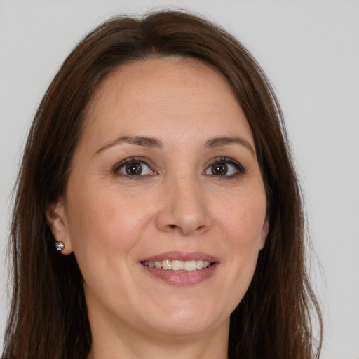 Joyful white adult female with long  brown hair and brown eyes