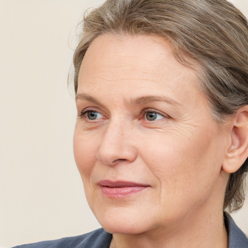 Joyful white adult female with medium  brown hair and blue eyes