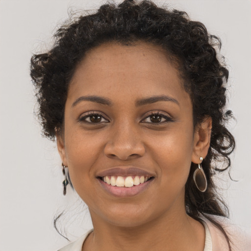Joyful black young-adult female with long  brown hair and brown eyes