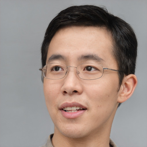 Joyful asian adult male with short  brown hair and brown eyes