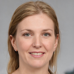 Joyful white adult female with medium  brown hair and blue eyes