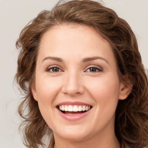 Joyful white young-adult female with long  brown hair and green eyes