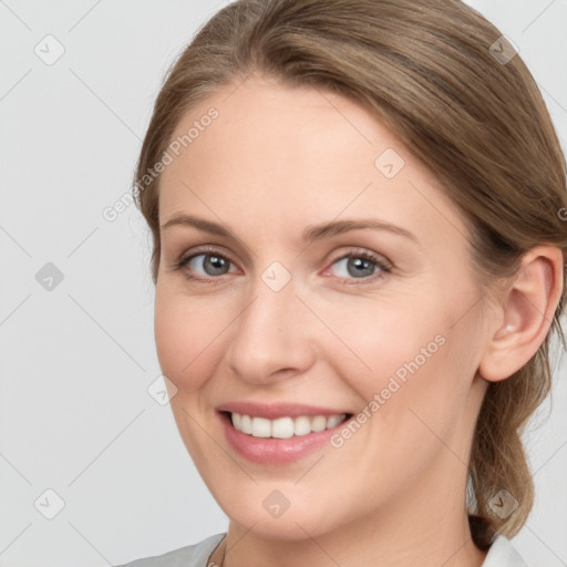 Joyful white young-adult female with medium  brown hair and grey eyes