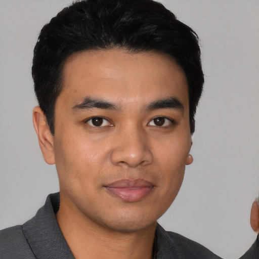 Joyful asian young-adult male with short  black hair and brown eyes