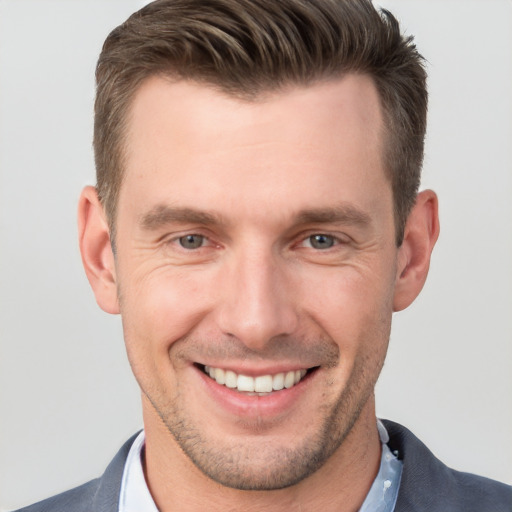 Joyful white young-adult male with short  brown hair and grey eyes