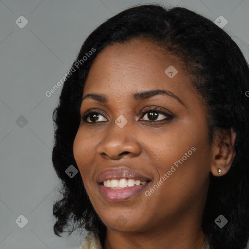 Joyful black young-adult female with long  black hair and brown eyes