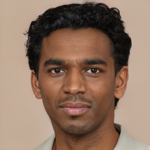 Joyful black young-adult male with short  black hair and brown eyes