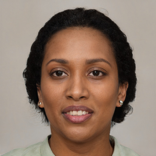 Joyful black young-adult female with short  brown hair and brown eyes