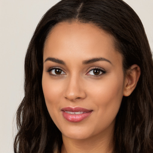 Joyful latino young-adult female with long  brown hair and brown eyes