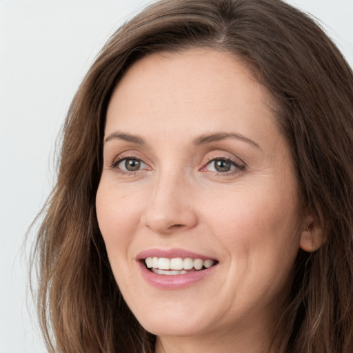 Joyful white young-adult female with long  brown hair and grey eyes