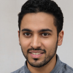 Joyful latino young-adult male with short  black hair and brown eyes