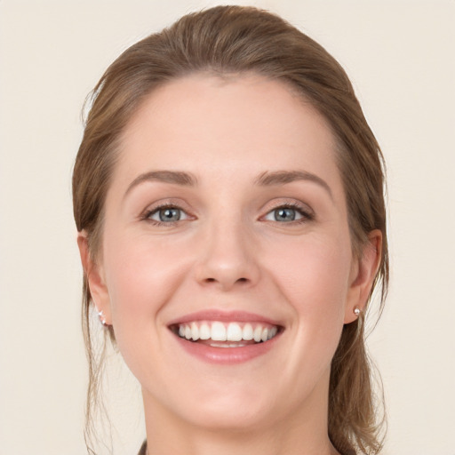 Joyful white young-adult female with medium  brown hair and blue eyes