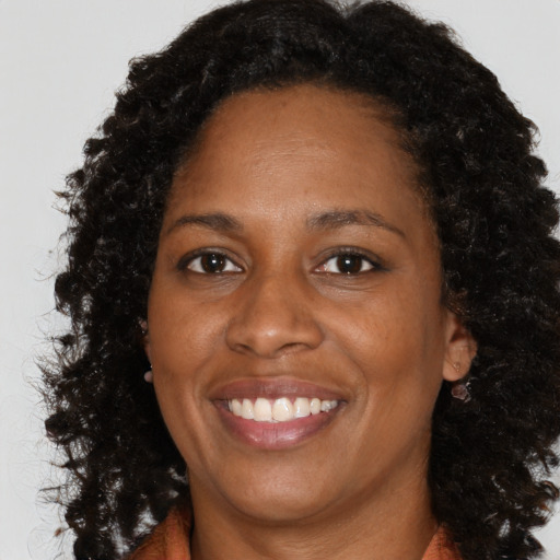 Joyful black adult female with long  brown hair and brown eyes