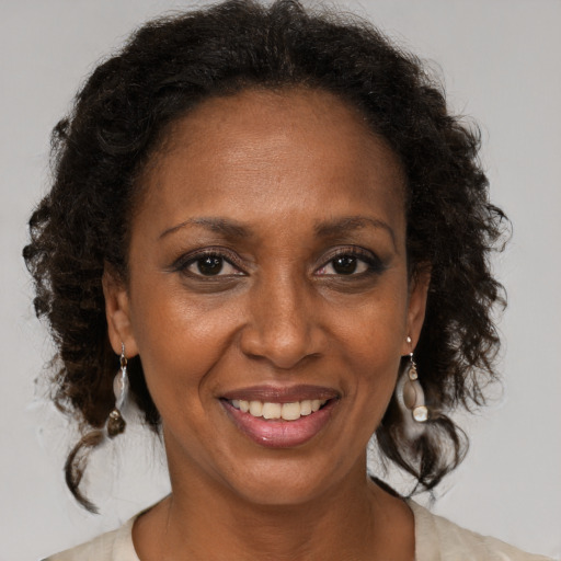 Joyful black adult female with medium  brown hair and brown eyes