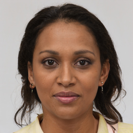 Joyful black adult female with medium  brown hair and brown eyes