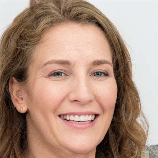 Joyful white adult female with long  brown hair and green eyes