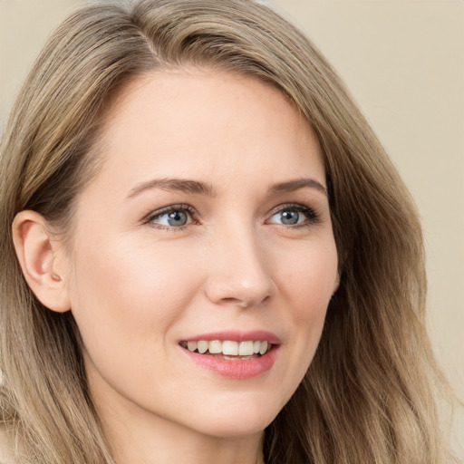 Joyful white young-adult female with long  brown hair and blue eyes