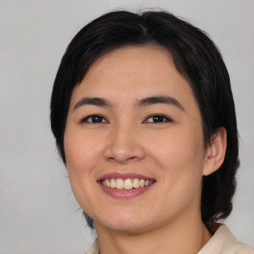 Joyful asian young-adult female with medium  black hair and brown eyes