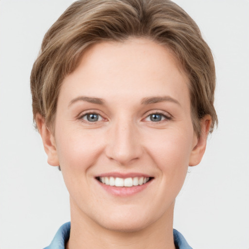 Joyful white young-adult female with short  brown hair and grey eyes