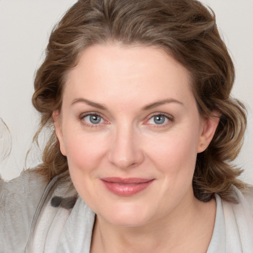 Joyful white young-adult female with medium  brown hair and blue eyes