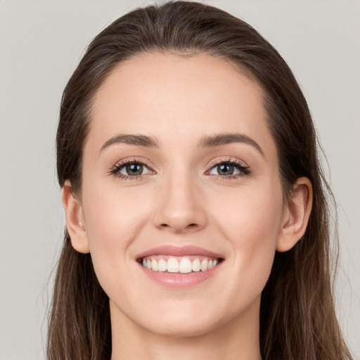 Joyful white young-adult female with long  brown hair and grey eyes