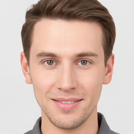 Joyful white young-adult male with short  brown hair and grey eyes