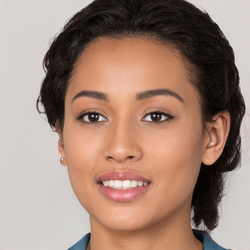 Joyful latino young-adult female with medium  brown hair and brown eyes