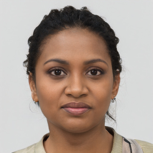 Joyful black young-adult female with short  black hair and brown eyes