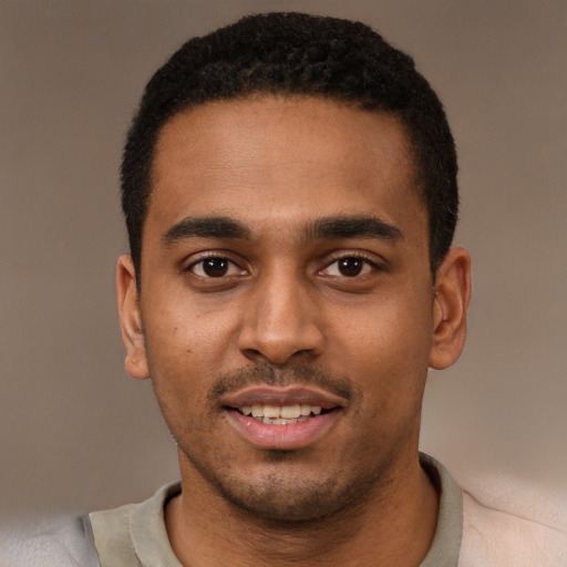 Joyful black young-adult male with short  black hair and brown eyes