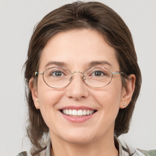 Joyful white adult female with medium  brown hair and grey eyes