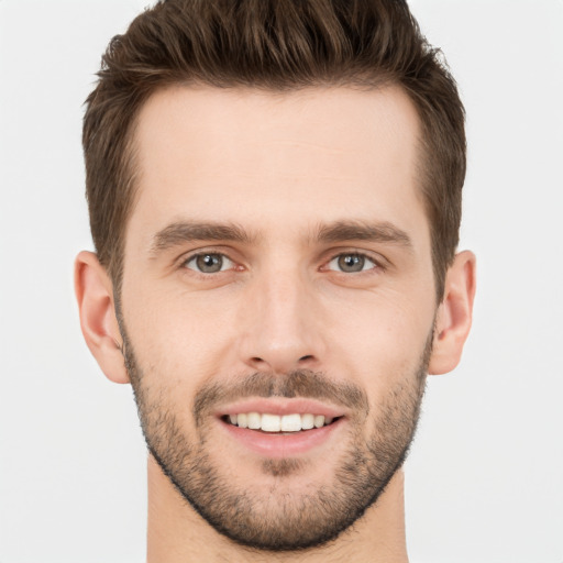 Joyful white young-adult male with short  brown hair and grey eyes