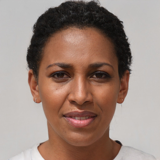 Joyful black adult female with short  black hair and brown eyes